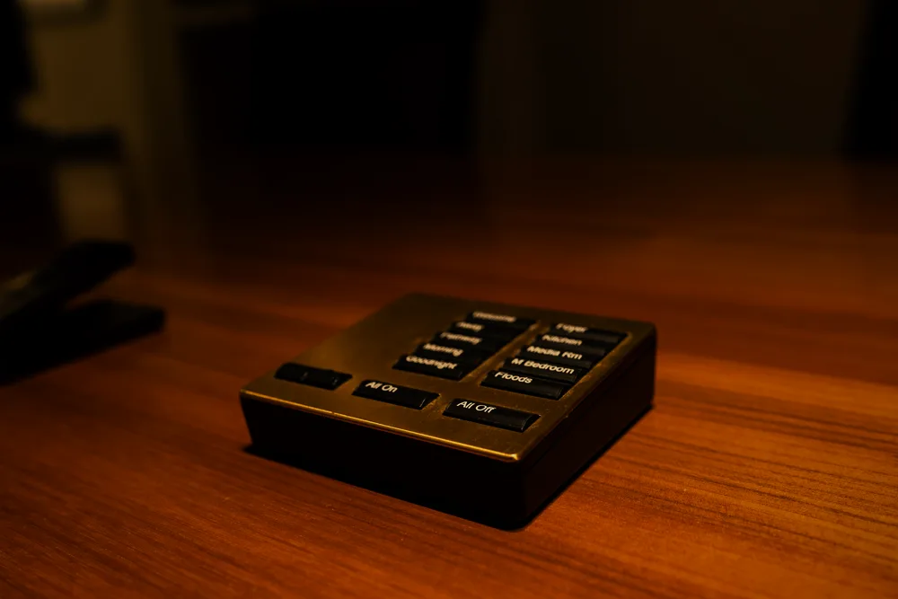 Lutron Palladiom brass keypad flush-mounted on dark wood