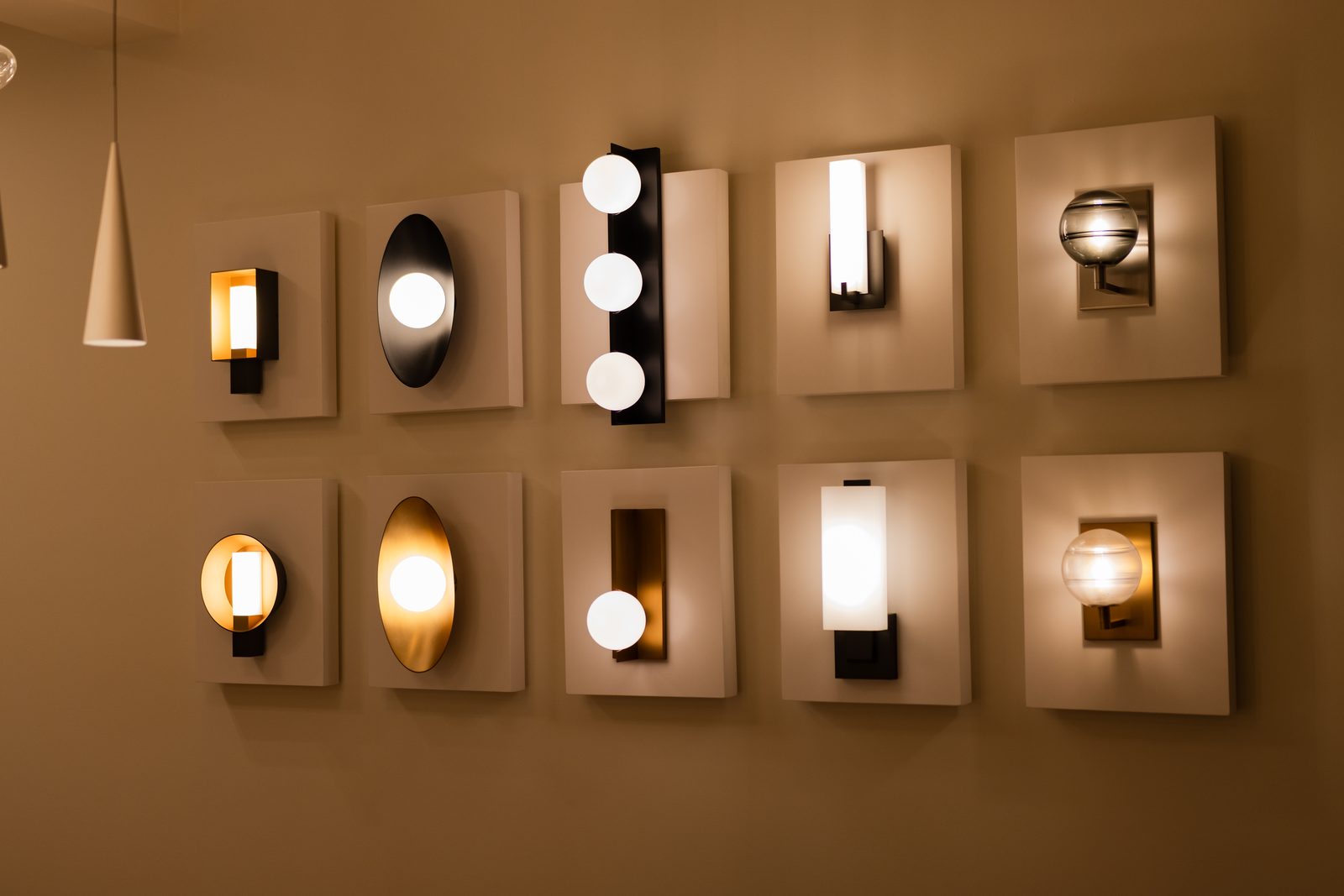 Wall display of ten architectural wall sconces lit in a Santo Domingo showroom